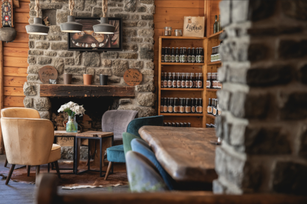 Salle de restaurant de montagne, vaste en pierre, murs en bois et siège cosy en velours